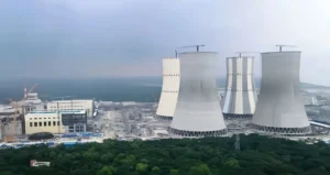 Industrial cooling towers near coastline.