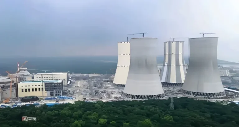Industrial cooling towers near coastline.