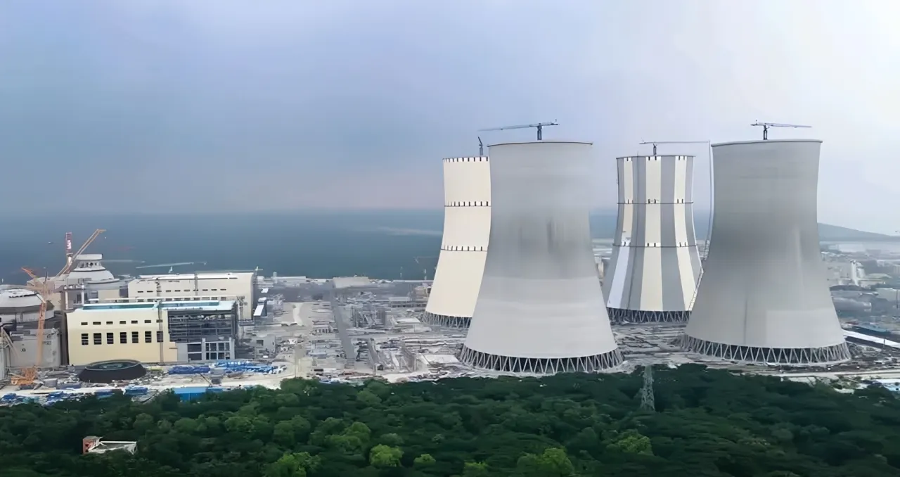 Industrial cooling towers near coastline.